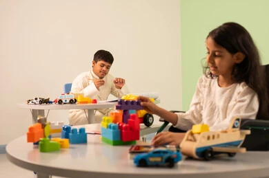 الابداع وتنمية المهارات الذهنيه والفكريه في الروضات السعودية ، تشجيع ورعاية وتطوير مهارات الأطفال،نشاطات ترفيهية لذوي الاحتياجات الخاصة ، اهتمام المجتمع السعودي بأصحاب الهمم, بنت عربيه سعوديه ترتدي الزي الكاجوال تجلس على كرسي متحرك، تقوم بتركيب المكعبات بتعابير السعاده ،ولد عماني مصاب بمتلازمه داون يقوم بالرسم والتلوين