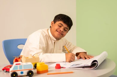 مفهوم الاهتمام بالهوايات،  قضاء اوقات ممتعه ،تنمية المهارات الذهنيه والفكريه في الروضات السعودية ،تعابير السعاده والسرور،ولد سعودي مصاب بمتلازمه داون يقوم باللعب بالمكعبات