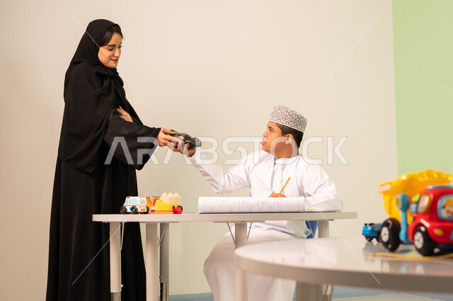 تنمية المهارات الذهنيه والفكريه في الروضات السعودية ،  تعابير السعاده والسرور، قضاء اوقات ممتعه ،ولد عربي عماني مصاب بمتلازمه داون ويقوم باللعب بالمكعبات برفقه معملته،مفهوم الاهتمام بالهوايات