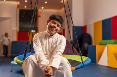 ايماءات السرور والسعاده ، ولد سعودي مصاب بمتلازمة داون في مدينة الألعاب ، يلعب لعبة المراجيح المسلية، الاستمتاع باللعب في العطلة الصيفية ،قضاء اوقات رائعة في مدينة الملاهي ، اوقات التسلية و الترفيه