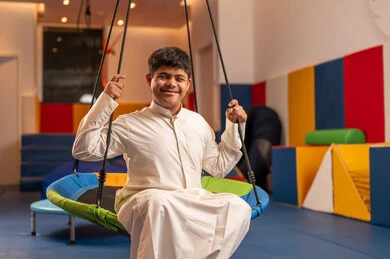 قضاء اوقات رائعة في مدينة الملاهي ،ايماءات السرور والسعاده ، ولد سعودي مصاب بمتلازمة داون في مدينة الألعاب ، يلعب لعبة المراجيح المسلية، الاستمتاع باللعب في العطلة الصيفية ، اوقات التسلية و الترفيه