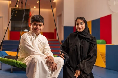 الاستمتاع باللعب في العطلة الصيفية ، اوقات التسلية و الترفيه ،ايماءات السرور والسعاده ، قضاء اوقات رائعة في مدينة الملاهي ،ولد سعودي مصاب بمتلازمة داون في مدينة الألعاب برفقه والدته، يلعب لعبة المراجيح المسلية