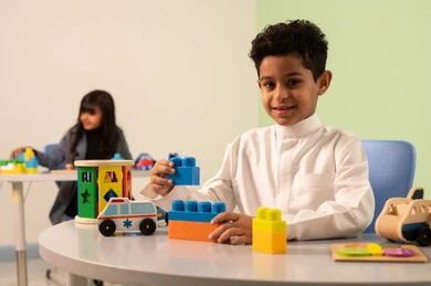 رياض الأطفال والحاضنات، بنت عربية خليجية عمانية ترتدي الزي الكاجوال تقوم بالمهارات والانشطه،تنمية المهارات الذهنية والفكرية ،أداء الكثير من الأنشطة الممتعة ، الاعتناء بمهارات الاطفال،ولد سعودي يلعب بالمكعبات الملونه