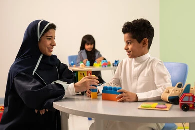 معلمة عربية عمانيه لرياض أطفال تختص بالاعتناء بالاطفال، رياض الأطفال والحاضنات،أداء الكثير من الأنشطة الممتعة ، ولد عربي خليجي عماني يرتدي الزي العماني التقليدي يقوم بالمهارات والانشطه برفقه معلمته ، بنت عمانية تلعب بالالعاب البلاستيكيه