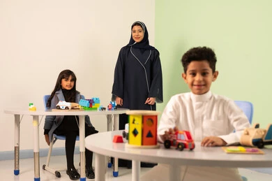 Fun in the summer vacation, an Omani Arab teacher for kindergarten specializing in caring for children, performing many enjoyable activities, kindergartens and nurseries, two Omani children engaging in various activities, spending wonderful times at the amusement park, games for entertainment and leisure.