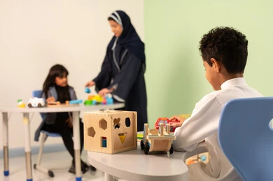 An Omani Arabic teacher for kindergarten specializes in taking care of children, performing many fun activities, kindergartens and nurseries, two Omani children engaging in various activities, spending wonderful times at the amusement park, games for fun and entertainment, enjoyment during the summer vacation.