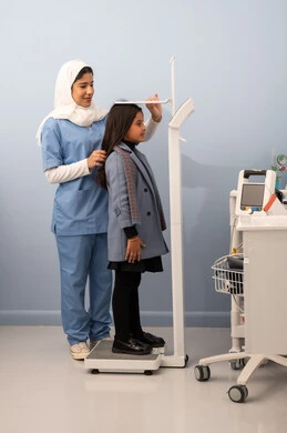 Suffering from health problems, the concept of health and fitness, excess weight and obesity, the accumulation of calories, a Saudi Arabian Gulf girl with a full body suffering from obesity, using a scale to measure weight.
