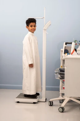 Caloric accumulation, the concept of health and fitness awareness, excess weight and obesity, an Arab Saudi Gulf boy with a full body suffering from obesity, using a scale to measure weight, suffering from health problems.
