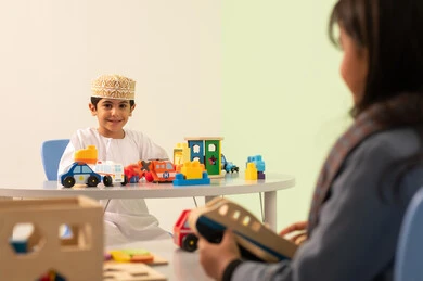 أداء الكثير من الأنشطة الممتعة ، رياض الأطفال والحاضنات، الاعتناء بمهارات الاطفال ، بنت عربية خليجية عمانية ترتدي الزي الكاجوال تقوم بالمهارات والانشطه، ولد سعودي يلعب بالالعاب البلاستيكيه الملونه