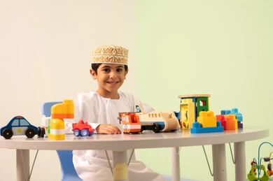 تنمية المهارات الذهنيه والفكريه ، قضاء اوقات ممتعه ، ولد عربي خليجي عماني يرتدي الدشداشه والكمه يجلس في رياض الأطفال والحاضنات ،يقوم بالعديد من الأنشطة الممتعة والمختلفة، الاستمتاع بالالعاب الترفيهيه ، مجموعة أنشطة فردية