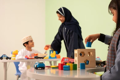 معلمة عربية عمانيه لرياض أطفال تختص بالاعتناء بالاطفال ،ولد عماني يرتدي الدشداشه والكمه في رياض الأطفال والحاضنات ،يقوم بالعديد من الأنشطة الممتعة والمختلفة، مجموعة أنشطة فردية