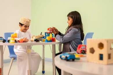 مجموعة أنشطة جماعية، طفلان عمانيان يجلسان في رياض الأطفال والحاضنات ،يقومان بالعديد من الأنشطة الممتعة والمختلفة، الاستمتاع بالالعاب الترفيهيه ، تنمية المهارات الذهنيه والفكريه