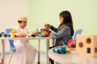 طفلان عمانيان يجلسان في رياض الأطفال والحاضنات ،يقومان بالعديد من الأنشطة الممتعة والمختلفة، الاستمتاع بالالعاب الترفيهيه ، تنمية المهارات الذهنيه والفكريه ، مجموعة أنشطة جماعية