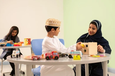 ولد عماني يرتدي الدشداشه والكمه في رياض الأطفال والحاضنات ،يقوم بالعديد من الأنشطة الممتعة والمختلفة،معلمة عربية عمانيه لرياض أطفال تختص بالاعتناء بالاطفال ،  مجموعة أنشطة فردية