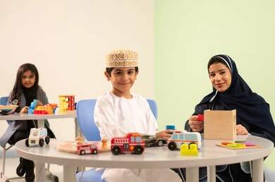 معلمة عربية عمانيه لرياض أطفال تختص بالاعتناء بالاطفال ، طفل عماني يرتدي الدشداشه والكمه في رياض الأطفال والحاضنات ،يقوم بالعديد من الأنشطة الممتعة والمختلفة، مجموعة أنشطة فردية