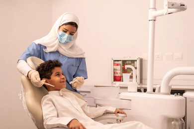 ولد عربي خليجي عماني يرتدي الزي العماني التقليدي يجلس على كرسي العلاج في العيادة السنية، تقديم الخدمات الطبية للمرضى ،مفهوم الطب والرعاية الصحية، استخدام المعدات اللازمة لجراحة الاسنان ، طبيبة ترتدي القفازات تقوم بفحص أسنان المريض، إجراء الفحوصات الدورية للعناية بالصحة الفموية