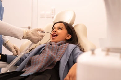 بنت عربية خليجية عمانية ترتدي الزي الكاجوال تجلس على كرسي العلاج في العيادة السنية، تقديم الخدمات الطبية للمرضى ،استخدام المعدات اللازمة لجراحة الاسنان ، مفهوم الطب والرعاية الصحية، طبيبة ترتدي القفازات تقوم بفحص أسنان المريض،  إجراء الفحوصات الدورية للعناية بالصحة الفموية