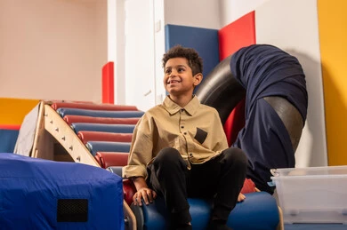 مدينه الالعاب في سلطنة عمان ، مفهوم اللهو واللعب،اجواء صيفية ممتعة، ، ولد عربي خليجي عماني يرتدي الزي الكاجوال  مستمتع بالتزحلق على الزحليقة ، الاستمتاع بالالعاب الترفيهية، العاب التسلية والمتعه