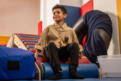 The concept of play and amusement, enjoyable summer atmosphere, amusement city in the Sultanate of Oman, an Arab Gulf Omani boy wearing casual attire enjoying sliding down the slide, enjoying recreational games, fun and entertainment games.