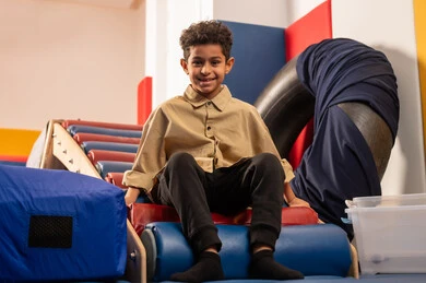 اجواء صيفية ممتعة، مفهوم اللهو واللعب،  مدينه الالعاب في سلطنة عمان، ولد عربي خليجي عماني يرتدي الزي الكاجوال  مستمتع بالتزحلق على الزحليقة ، الاستمتاع بالالعاب الترفيهية، العاب التسلية والمتعه