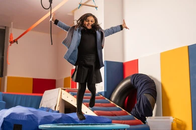 الاستمتاع بالالعاب الترفيهية، مفهوم اللهو واللعب، القفز عالياً بايماءات السعادة والسرور، اجواء صيفية ممتعة، مدينه الالعاب في المملكة العربية السعودية، بنت عربية خليجية سعودية مستمتعة بالتزحلق على الزحليقة ، العاب التسلية والمتعه