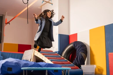 القفز عالياً بايماءات السعادة والسرور، مفهوم اللهو واللعب،اجواء صيفية ممتعة، مدينه الالعاب في المملكة العربية السعودية، بنت عربية خليجية سعودية مستمتعة بالتزحلق على الزحليقة ، الاستمتاع بالالعاب الترفيهية، العاب التسلية والمتعه