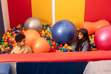 العاب التسلية و الترفيه ،طفلان سعوديان يرتديان الزي الكاجوال في مدينة الألعاب ، يلعبان في حوض الكور البلاستيكية ، طفلان عمانيان يقضيان اوقات رائعة في مدينة الملاهي ، المتعه في العطلة الصيفية