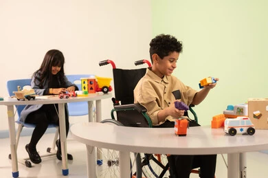 الاعتناء بالاطفال ذوي الاحتياجات الخاصة، أداء الكثير من الأنشطة الممتعة لذوي الهمم، رياض الأطفال والحاضنات، بنت عربية خليجية عمانية ترتدي الزي الكاجوال تقوم بالمهارات والانشطه، ولد سعودي يلعب بالالعاب البلاستيكيه الملونه