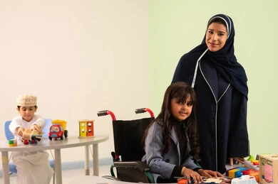 أداء الكثير من الأنشطة الممتعة لذوي الهمم، ولد عماني يلعب بالالعاب البلاستيكيه، معلمة عربية عمانيه لرياض أطفال تختص بالاعتناء بطفل ذوي الاحتياجات الخاصة، رياض الأطفال والحاضنات، بنت عربية خليجية عمانية ترتدي الزي الكاجوال تقوم بالمهارات والانشطه برفقه معلمتها