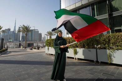 ذكرى تأسيس الاتحاد 2 ديسمبر،استذكار اليوم الوطني الاماراتي 1971، إمراة عربية خليجية إماراتية ترتدي الحجاب والعباءة تمسك بيدها علم الإمارات العربية المتحدة ، يوم العلم 3 نوفمبر، حب الوطن والاعتزاز به، التجول في الشوارع بايماءات السعادة والفخر والاعتزاز