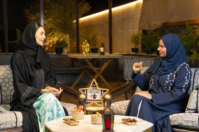 تناول التمر السكري الطازج، منتج وطني محلي اماراتي، حسن الاستقبال في شهر رمضان المبارك، زينة واضاءة رمضانية، امراتان سعوديتان تجلسان بالجلسة الخارجية في احدى شاليهات الامارات، صديقتان عربيتان خليجيتان اماراتيتان ترتديان العباءة تجلسان في الهواء الطلق