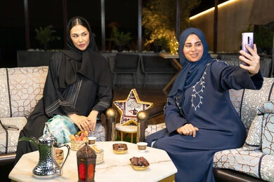 كرم الضيافة وحسن الاستقبال في شهر رمضان المبارك، امراتان سعوديتان تقومان بتوثيق اللحظات السعيدة، التقاط صور سيلفي باستخدام الهاتف المحمول، صديقتان عربيتان خليجينان اماراتيتان ترتديان العباءة تجلسان في الهواء الطلق، زينة واضاءة رمضانية، الجلسة الليلة الخارجية كرم الضيافة وحسن الاستقبال في شهر رمضان المبارك، امراتان سعوديتان تقومان بتوثيق اللحظات السعيدة، التقاط صور سيلفي باستخدام الهاتف المحمول، صديقتان عربيتان خليجينان اماراتيتان ترتديان العباءة تجلسان في الهواء الطلق، زينة واضاءة رمضانية، الجلسة الليلة الخارجية