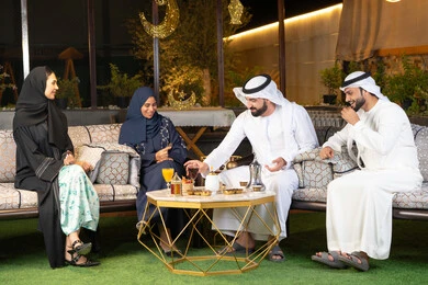 زينة واضاءة رمضانية، الجلسة الليلة الخارجية في احدى شاليهات الامارات، حسن الاستقبال وكرم الضيافة في شهر رمضان المبارك، مجموعة من الأصدقاء العرب الخليجيين الاماراتيين يجلسون في الهواء الطلق، تبادل الاحاديث والاخبار بتعابير السرور والسعادة