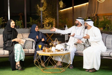 ديكور واضاءة رمضانية، الجلسة الليلة الخارجية في احدى شاليهات الامارات، حسن الاستقبال وكرم الضيافة في شهر رمضان المبارك، مجموعة من الأصدقاء العرب الخليجيين الاماراتيين يجلسون في الهواء الطلق، تبادل الاحاديث والاخبار بتعابير السرور والسعادة