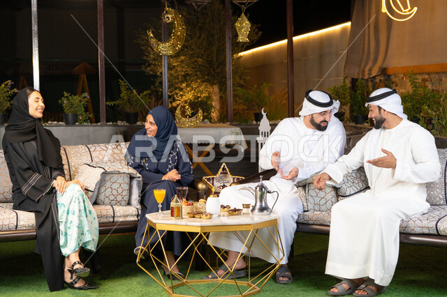 حسن الاستقبال وكرم الضيافة في شهر رمضان المبارك، الجلسة الليلة الخارجية في احدى شاليهات الامارات، زينة واضاءة رمضانية، مجموعة من الأصدقاء العرب الخليجيين الاماراتيين يجلسون في الهواء الطلق، تبادل الاحاديث والاخبار بتعابير السرور والسعادة