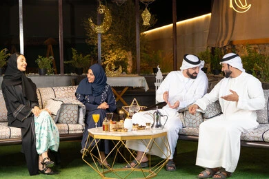 حسن الاستقبال وكرم الضيافة في شهر رمضان المبارك، الجلسة الليلة الخارجية في احدى شاليهات الامارات، زينة واضاءة رمضانية، مجموعة من الأصدقاء العرب الخليجيين الاماراتيين يجلسون في الهواء الطلق، تبادل الاحاديث والاخبار بتعابير السرور والسعادة