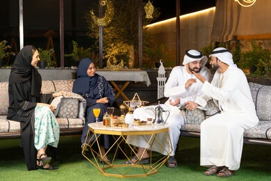 زينة واضاءة رمضانية، الجلسة الليلة الخارجية في احدى شاليهات الامارات، حسن الاستقبال وكرم الضيافة في شهر رمضان المبارك، مجموعة من الأصدقاء العرب الخليجيين الاماراتيين يجلسون في الهواء الطلق، تبادل الاحاديث والاخبار بتعابير السرور والسعادة