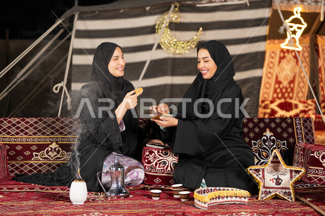 وجبة افطار ذات قيمة غذائية عالية, كرات العجين المقلية الصغيرة, مأكولات على المائدة في شهر رمضان, حسن الاستقبال وكرم الضيافه، سيده امارتيه تقوم بتقدم المقبلات لصديقتها، امراءه سعوديه تحمل بيدها طبق مليئ بالمأكولات