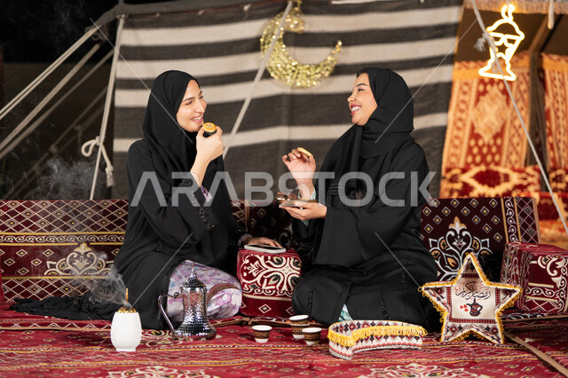 وجبة افطار ذات قيمة غذائية عالية, كرات العجين المقلية الصغيرة, مأكولات على المائدة في شهر رمضان, حسن الاستقبال وكرم الضيافه، سيده امارتيه تقوم بتقدم المقبلات لصديقتها، امراءه سعوديه تحمل بيدها طبق مليئ بالمأكولات