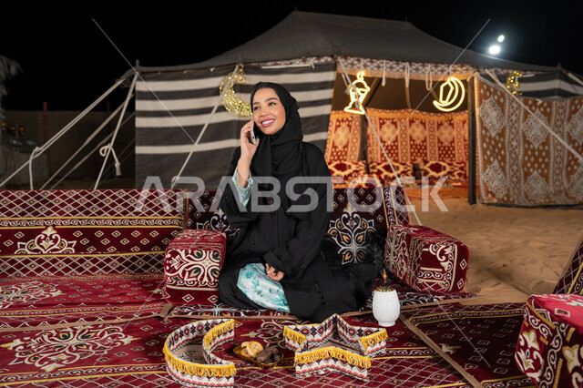 قضاء اوقات ممتعة بتبادل الاخبار والأحاديث، التواصل والاطمئنان على الأصدقاء, امرأة عربية سعودية خليجية محجبة تقوم بإجراء مكالمة صوتية عبر الهاتف، سيده اماراتيه تقوم بالرد على الاتصالات بإستخدام الهاتف المحمول، استخدام التقنيات والاجهزه الحديثه