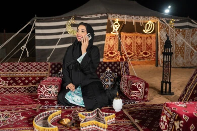 قضاء اوقات ممتعة بتبادل الاخبار والأحاديث، التواصل والاطمئنان على الأصدقاء, امرأة عربية سعودية خليجية محجبة تقوم بإجراء مكالمة صوتية عبر الهاتف، سيده اماراتيه تقوم بالرد على الاتصالات بإستخدام الهاتف المحمول، استخدام التقنيات والاجهزه الحديثه