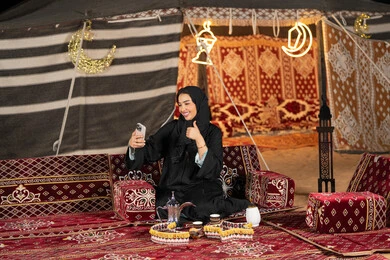 ديكور وزينه شهر رمضان، سيده اماراتيه ترتدي العباءه السوداء تقوم باجراء مكالمه فيديو مع الاصدقاء، امرأه عربيه خليجيه سعوديه مبتسمه تقوم باستخدام الهاتف المحمول, المجلس الشعبي التقليدي، التقدم التقني للاجهزه، التواصل عن بعد، ايماءه الاعجاب والسرور ديكور وزينه شهر رمضان، سيده اماراتيه ترتدي العباءه السوداء تقوم باجراء مكالمه فيديو مع الاصدقاء، امرأه عربيه خليجيه سعوديه مبتسمه تقوم باستخدام الهاتف المحمول, المجلس الشعبي التقليدي، التقدم التقني للاجهزه، التواصل عن بعد، ايماءه الاعجاب والسرور