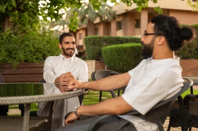 صديقان عربيان خليجيان سعوديان يقضيان الاوقات الممتعة في الأجواء الصيفية اللطيفة، تبادل أطراف الحديث بين العائلات والزملاء، الاستمتاع بعطلة نهاية الأسبوع برفقة الأصدقاء في المطاعم والكافيهات