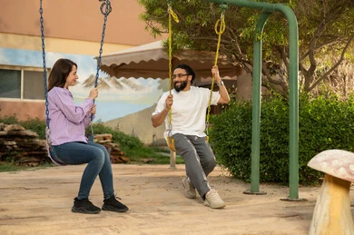 زوجان عربيان خليجيان سعوديان يجلسان على المرجيحة باحدي الحدائق الترفهيه بالسعودية ،يتبادلان الاحاديث في الأجواء الصيفية اللطيفة ،بناء علاقات اجتماعية ناجحة  ،تبادل أطراف الحديث بين العائلات والزملاء، الاستمتاع بعطلة نهاية الأسبوع برفقة الأصدقاء ،  نزهة في الهواء الطلق