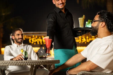 نادل يرتدي زي اليونيفورم يقوم بتقديم الطلبات ،بناء علاقات اجتماعية ناجحة وتبادل أطراف الحديث بين العائلات والزملاء، الاستمتاع بعطلة نهاية الأسبوع برفقة الأصدقاء في المطاعم والكافيهات، صديقان عربيان خليجيان سعوديان يقضون السهرات المسائية الممتعة في الأجواء الصيفية اللطيفة ، تناول المشروبات الباردة المنعشة  في الهواء الطلق