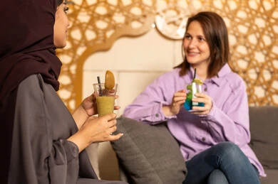 نزهة فى الهواء الطلق ، تبادل أطراف الحديث بين العائلات والزملاء، الاستمتاع بعطلة نهاية الأسبوع برفقة الأصدقاء في المطاعم والكافيهات، صديقتان عربيتان خليجيتان سعوديتان يقضون السهرات المسائية الممتعة في الأجواء الصيفية اللطيفة ، تناول المشروبات الباردة المنعشة