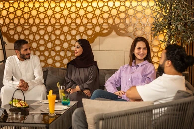 مجموعة اصدقاء عرب خليجيين سعوديين يقضون السهرات المسائية الممتعة في الأجواء الصيفية اللطيفة ، الاستمتاع بعطلة نهاية الأسبوع برفقة الأصدقاء في المطاعم والكافيهات، بناء علاقات اجتماعية ناجحة وتبادل أطراف الحديث بين العائلات والزملاء،تناول المشروبات الباردة المنعشة  في الهواء الطلق