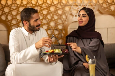 قضاء اوقات ممتعه ،  الاستمتاع بعطلة نهاية الأسبوع برفقة العائلة في المطاعم والكافيهات،  زوجان عربيان خليجيان سعوديان يقضون السهرات المسائية الممتعة في الأجواء الصيفية اللطيفة