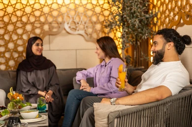 بناء علاقات اجتماعية ناجحة وتبادل أطراف الحديث بين العائلات والزملاء، الاستمتاع بعطلة نهاية الأسبوع برفقة الأصدقاء في المطاعم والكافيهات،مجموعة اصدقاء عرب خليجيين سعوديين يقضون السهرات المسائية الممتعة في الأجواء الصيفية اللطيفة ، تناول المشروبات الباردة المنعشة  في الهواء الطلق