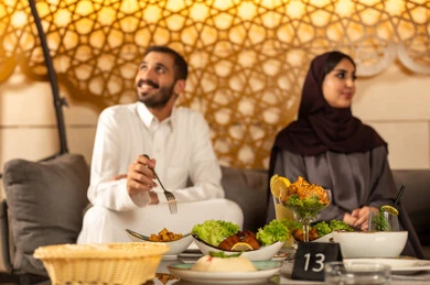 قضاء اوقات ممتعه ، تبادل أطراف الحديث بين العائلات والزملاء، الاستمتاع بعطلة نهاية الأسبوع برفقة الأصدقاء في المطاعم والكافيهات،  زوجان عربيان خليجيان سعوديان يقضون السهرات المسائية الممتعة في الأجواء الصيفية اللطيفة ، تناول المشروبات الباردة المنعشة  في الهواء الطلق